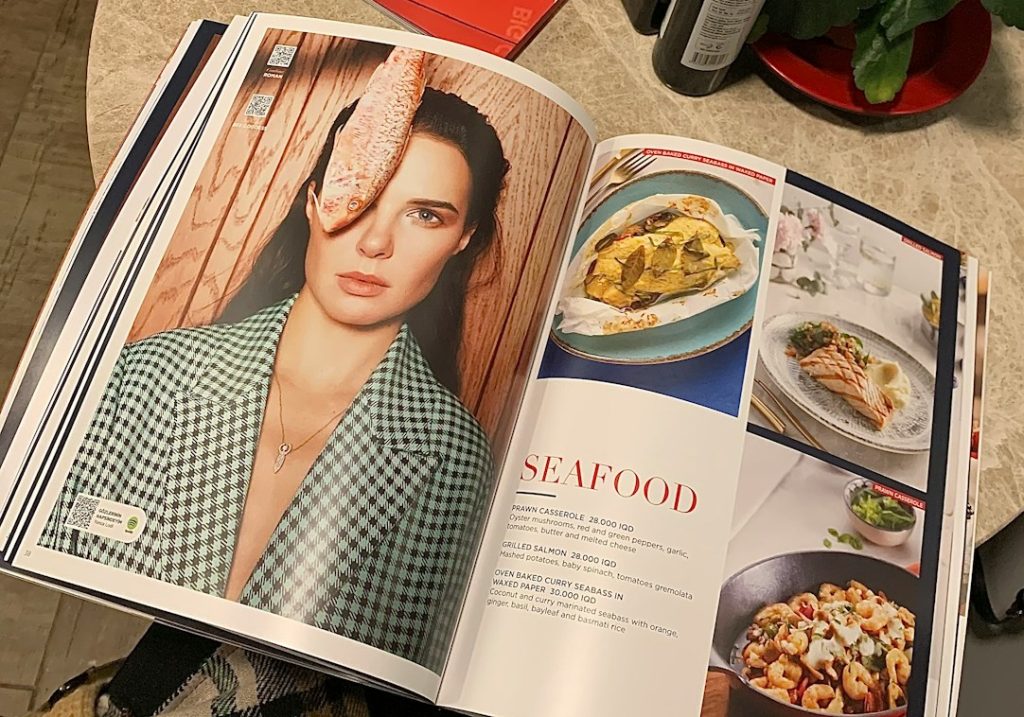 a person sitting at a table with a magazine open